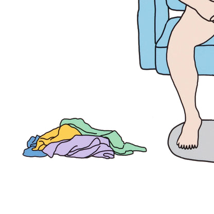 Colorful clothes on the floor next to a person sitting on a toilet.