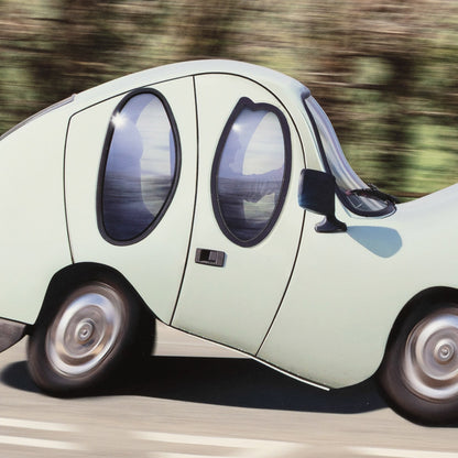 Light green cartoon car with large wheels on a road
