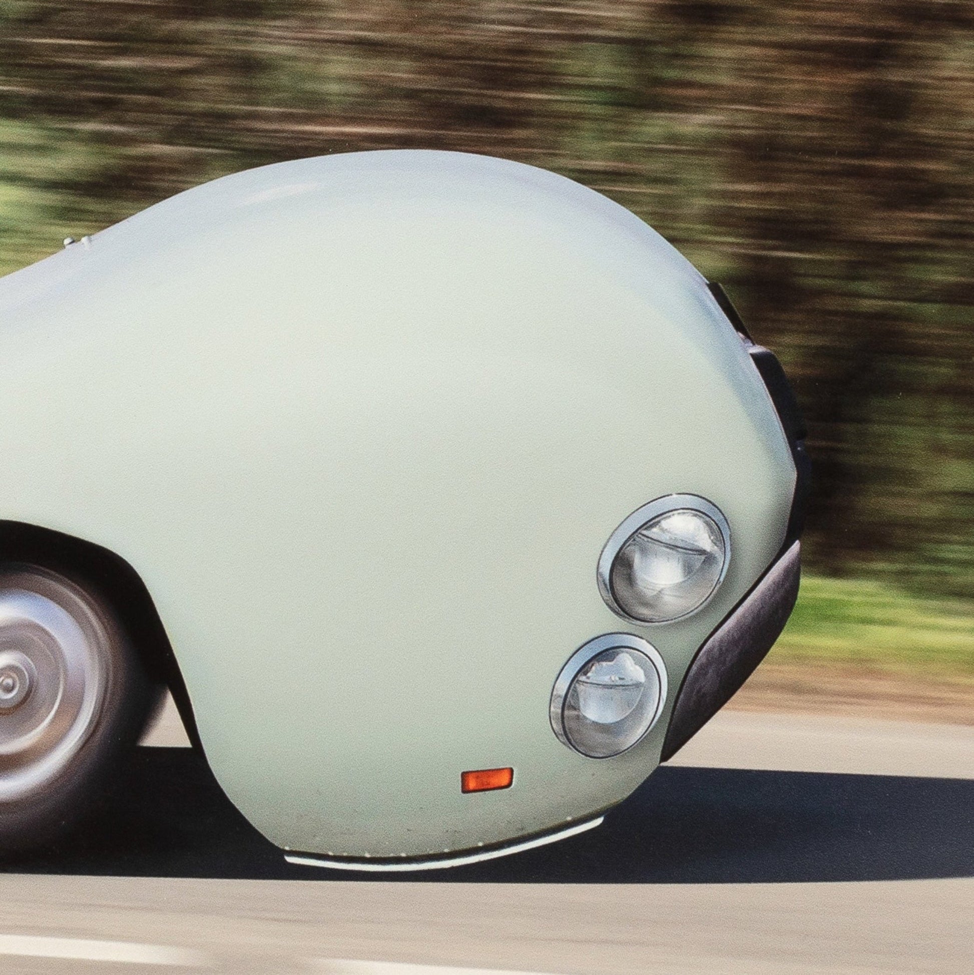 Vintage car driving on a road with a blurred background