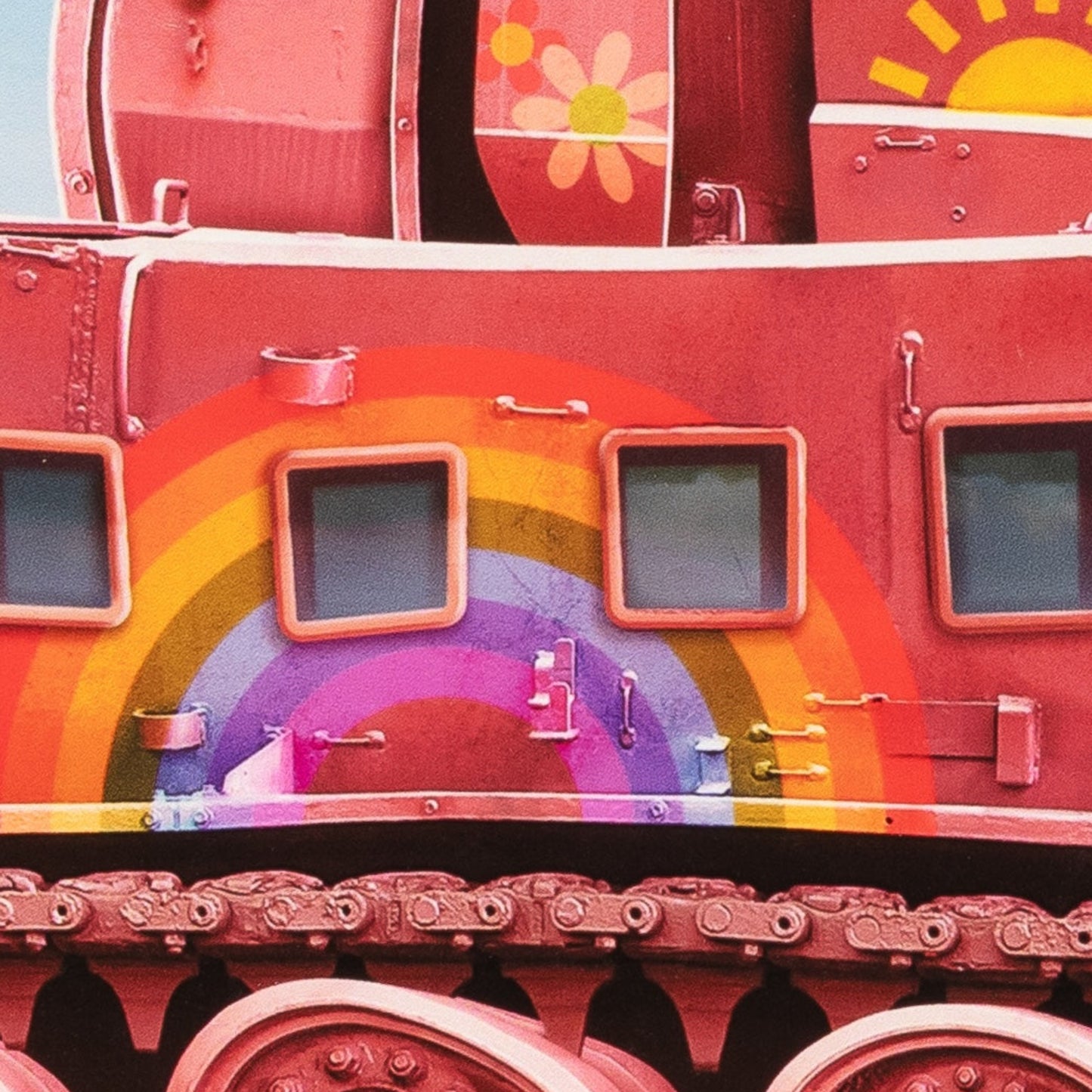 Close-up of a red train car with a rainbow design and cartoon elements.