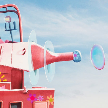 Red bubble machine with a blue sky background